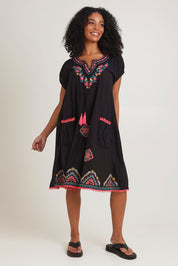 Model Ziara wearing size S of the Sao Paulo Cotton Dress in colour Rubyblk (Black), from the front, showing the whole outfit