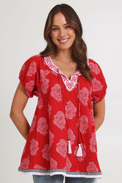 Model Madeline wearing size S of the Sao Paulo Cotton Top in colour Paisleyred (Red), from the front, cropped image