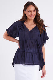 Model Madeline wearing size S of the Matilda Top in colour Navy (Blue), from the front, cropped image