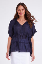 Model Madeline wearing size S of the Matilda Top in colour Navy (Blue), from the front, cropped image