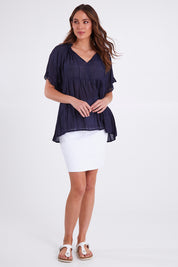 Model Madeline wearing size S of the Matilda Top in colour Navy (Blue), from the front, showing the whole outfit