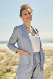 Model Lala wearing size 10 of the Cotton Linen Longline Blazer in colour Chambray (Blue), from the front, showing the whole outfit