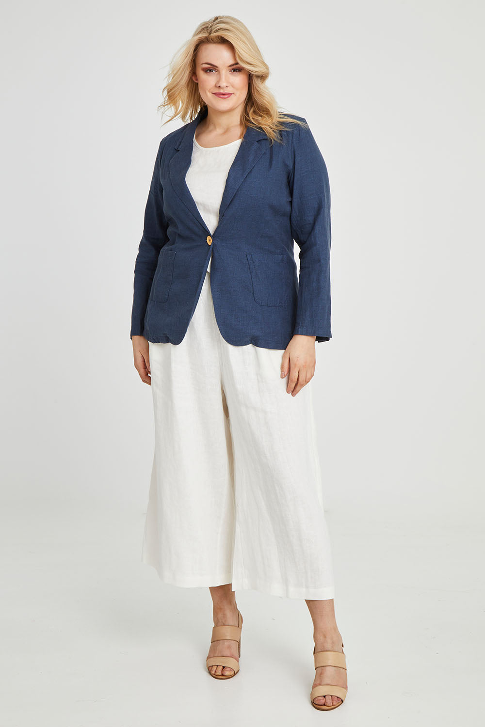 Model Keeara wearing size 16 of the Cotton Linen Longline Blazer in colour Deepocean (Blue), from the front, showing the whole outfit