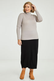 Model Fiona wearing size 16 of the Merino Wool Skivvy in colour Natural, from the front, showing the whole outfit