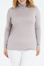 Model Jess wearing size 14 of the Merino Wool Skivvy in colour Natural, from the front, cropped image