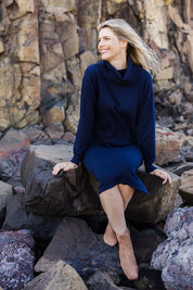 Model Kelly wearing size S of the Cotton Cashmere Rolled Neck Knit Dress in colour Navy (Blue), from the front, showing the whole outfit