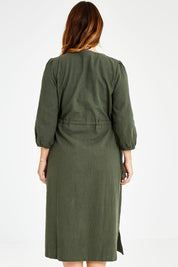 Model Laura wearing size 14 of the Ramie Empire Line Dress in colour Green (Green), from the back