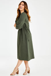 Model Laura wearing size 14 of the Ramie Empire Line Dress in colour Green (Green), from the front, showing the whole outfit