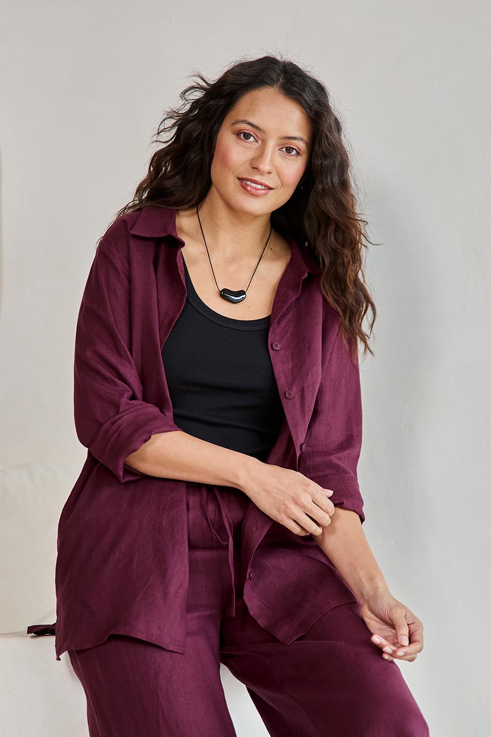 Model Tahneei wearing size 10 of the Linen Oversized Boyfriend Shirt – Plum in colour Plum, from an angle