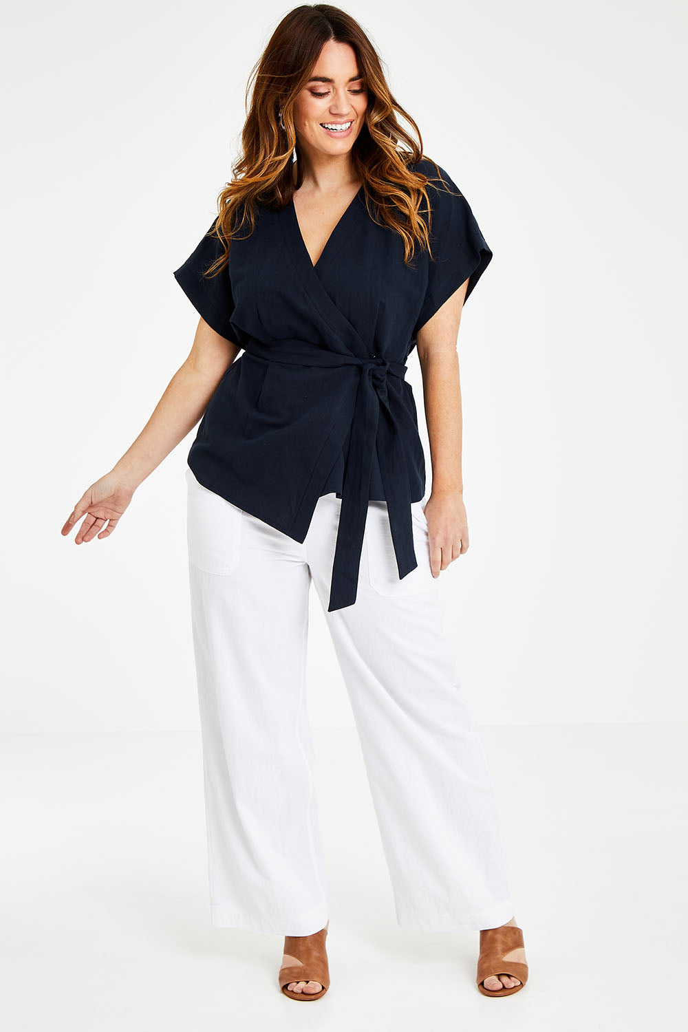 Model Laura wearing size 14 of the Linen Cotton Wrap Blouse in colour Navy (Blue), from the front, showing the whole outfit