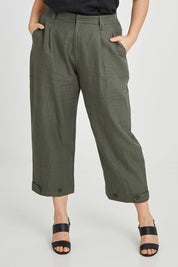 Model Keeara wearing size 16 of the Linen Cotton 7/8 Pant in colour Olive (Green), from the front, cropped image
