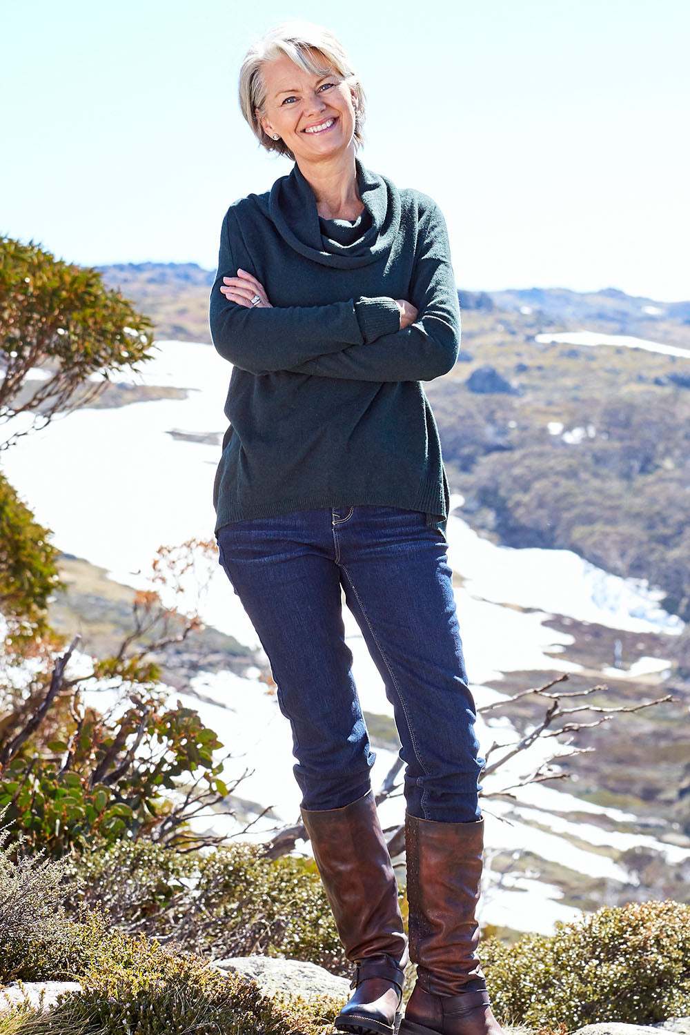 Model Charlotte wearing size S of the Natural Rolled Neck Sweater in colour Alpine (Green), from the front, showing the whole outfit