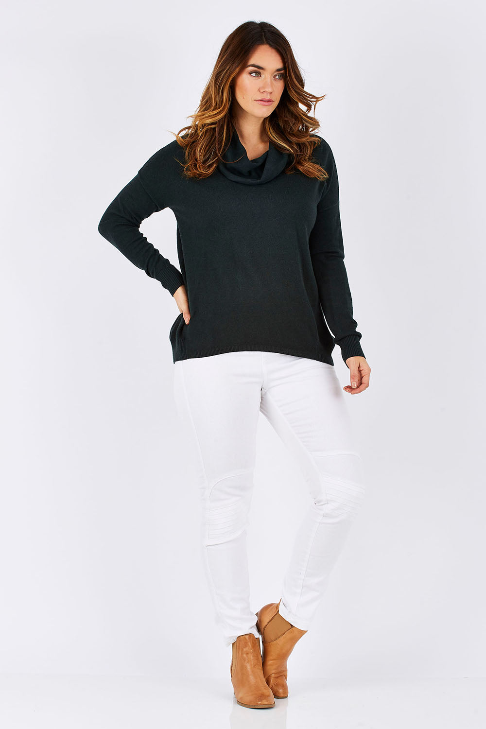 Model Laura wearing size M of the Natural Rolled Neck Sweater in colour Alpine (Green), from the front, showing the whole outfit