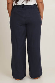 Model Ashleigh wearing size 16 of the Linen Wide Leg Pant in colour Navy (Blue), from the back