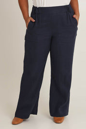 Model Ashleigh wearing size 16 of the Linen Wide Leg Pant in colour Navy (Blue), from the front, cropped image