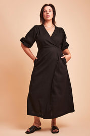 Model Poppy wearing size 16 of the Linen Cotton Blend Wrap Dress in colour Black (Black), from the front, showing the whole outfit