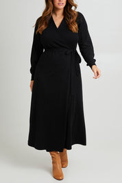Model Laura wearing size L of the Cotton Cashmere Wrap Dress in colour Black (Black), from the front, cropped image