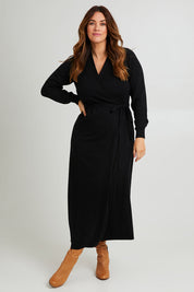 Model Laura wearing size L of the Cotton Cashmere Wrap Dress in colour Black (Black), from the front, showing the whole outfit