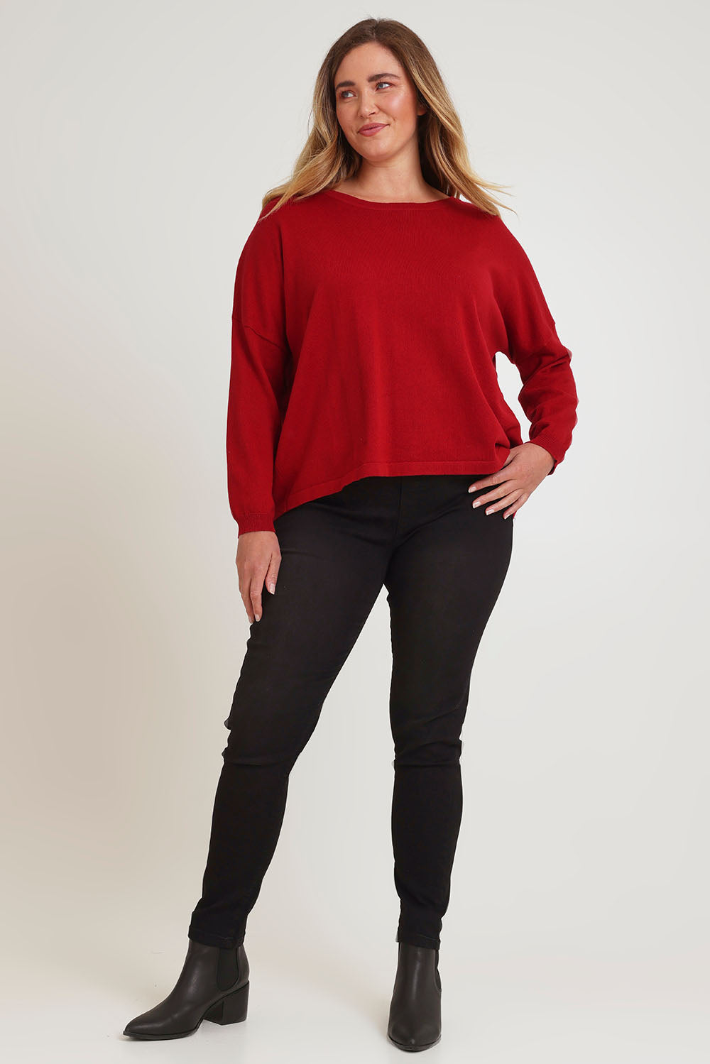 Model Chanel wearing size XL of the Cotton Cashmere Cross Back Sweater in colour Redrust (Red), from the front, showing the whole outfit