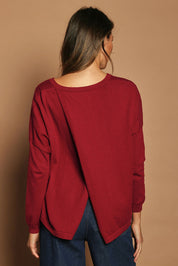Model Madeline wearing size S of the Cotton Cashmere Cross Back Sweater in colour Redrust (Red), from the back