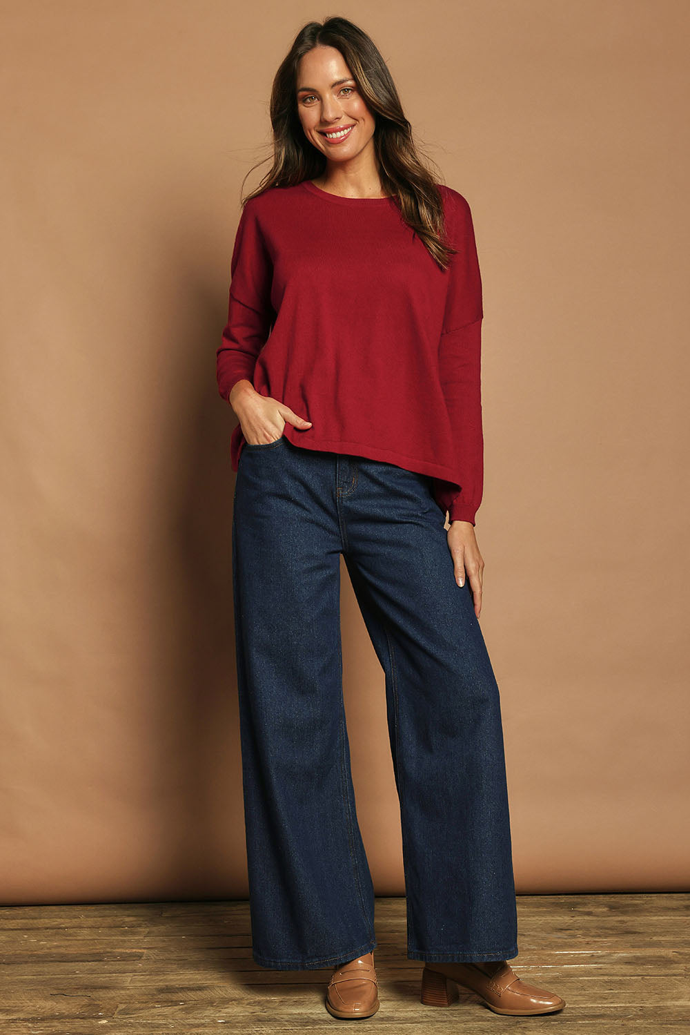 Model Madeline wearing size S of the Cotton Cashmere Cross Back Sweater in colour Redrust (Red), from the front, showing the whole outfit