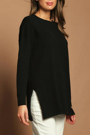 Model Madeline wearing size S of the Cotton Cashmere Tunic in colour Black (Black), from the front, cropped image