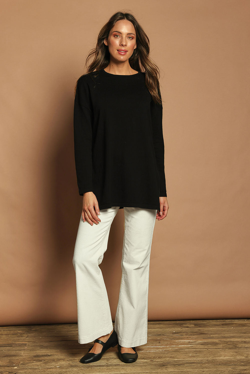 Model Madeline wearing size S of the Cotton Cashmere Tunic in colour Black (Black), from the front, showing the whole outfit