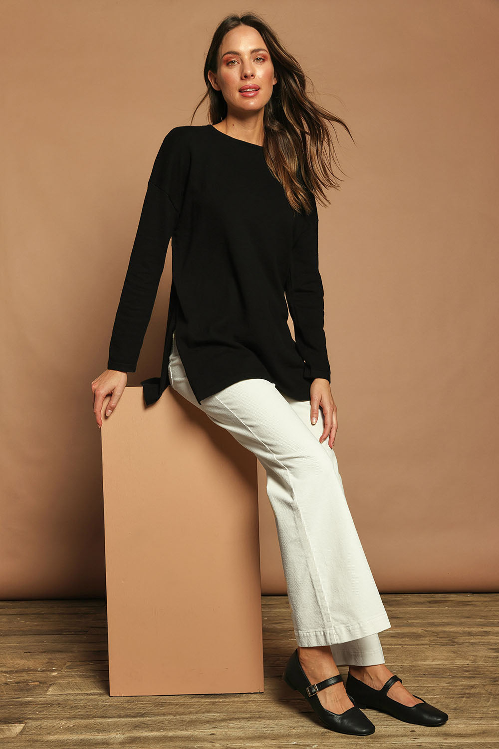 Model Madeline wearing size S of the Cotton Cashmere Tunic in colour Black (Black), from the front, showing the whole outfit