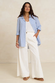 Model Tahnee wearing size 10 of the Cotton Oversized Stripe Boyfriend Shirt in colour Blue (Blue), from the front, showing the whole outfit