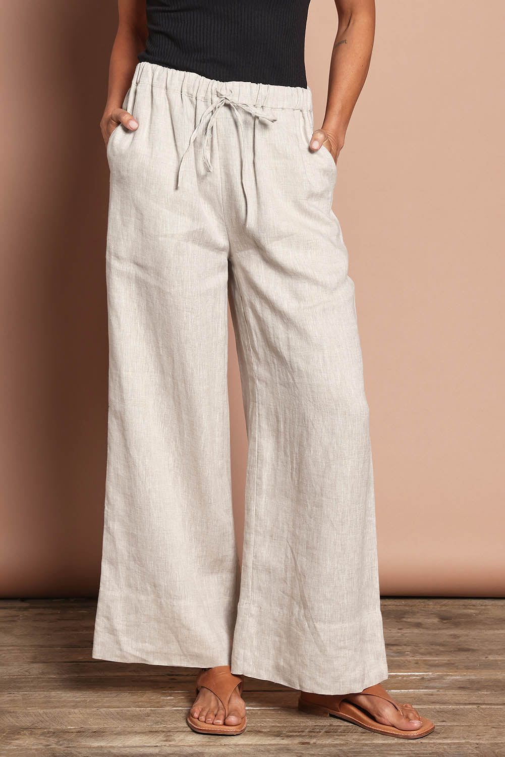 Model Amanda wearing size 10 of the Linen Drawstring Pant in colour Natural, from the front, cropped image