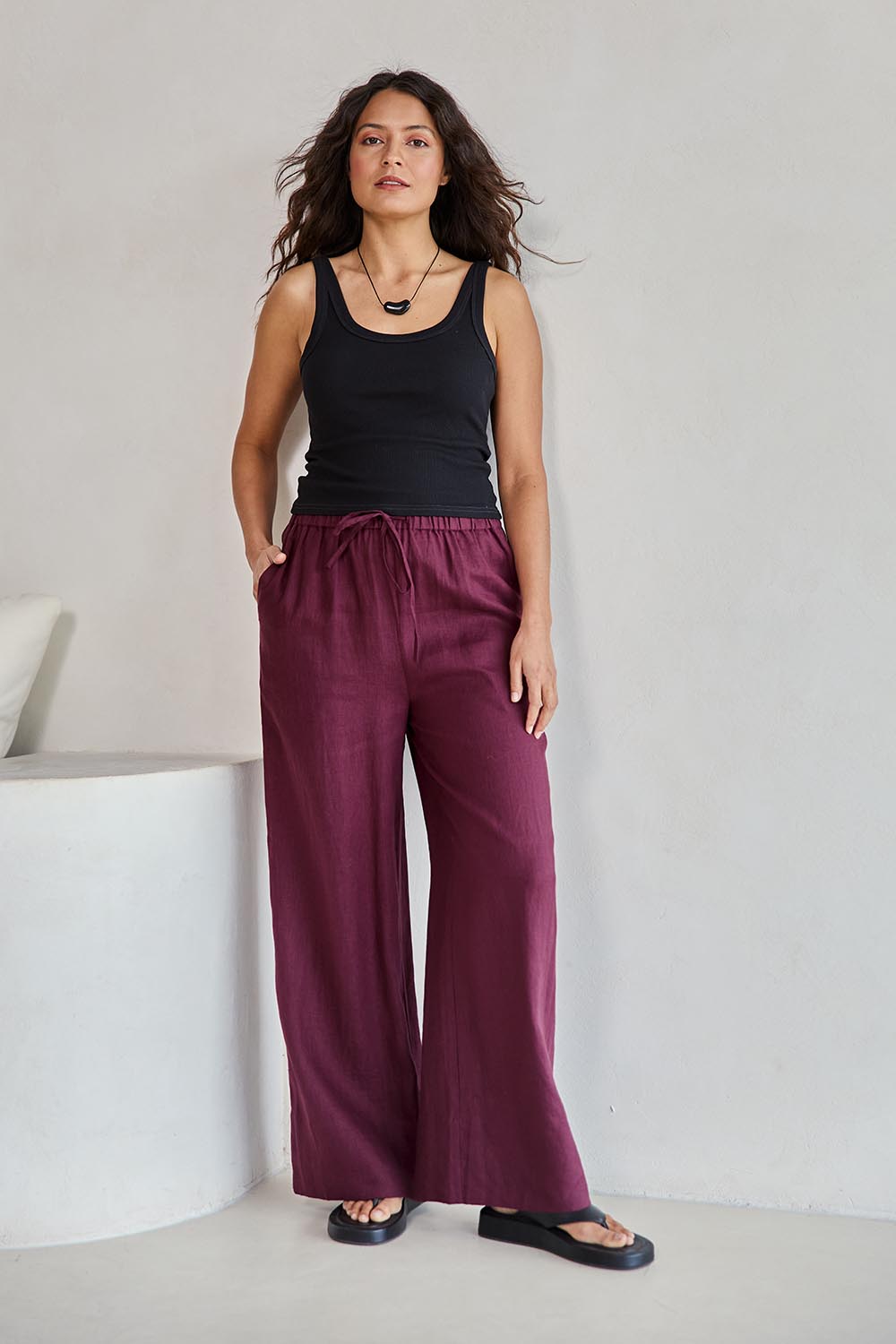 Model Tahneei wearing size 10 of the Linen Drawstring Pant – Plum in colour Plum, from the front