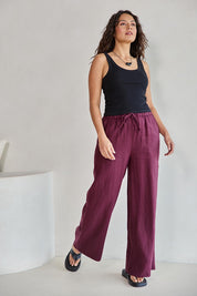 Model Tahneei wearing size 10 of the Linen Drawstring Pant – Plum in colour Plum, from the front