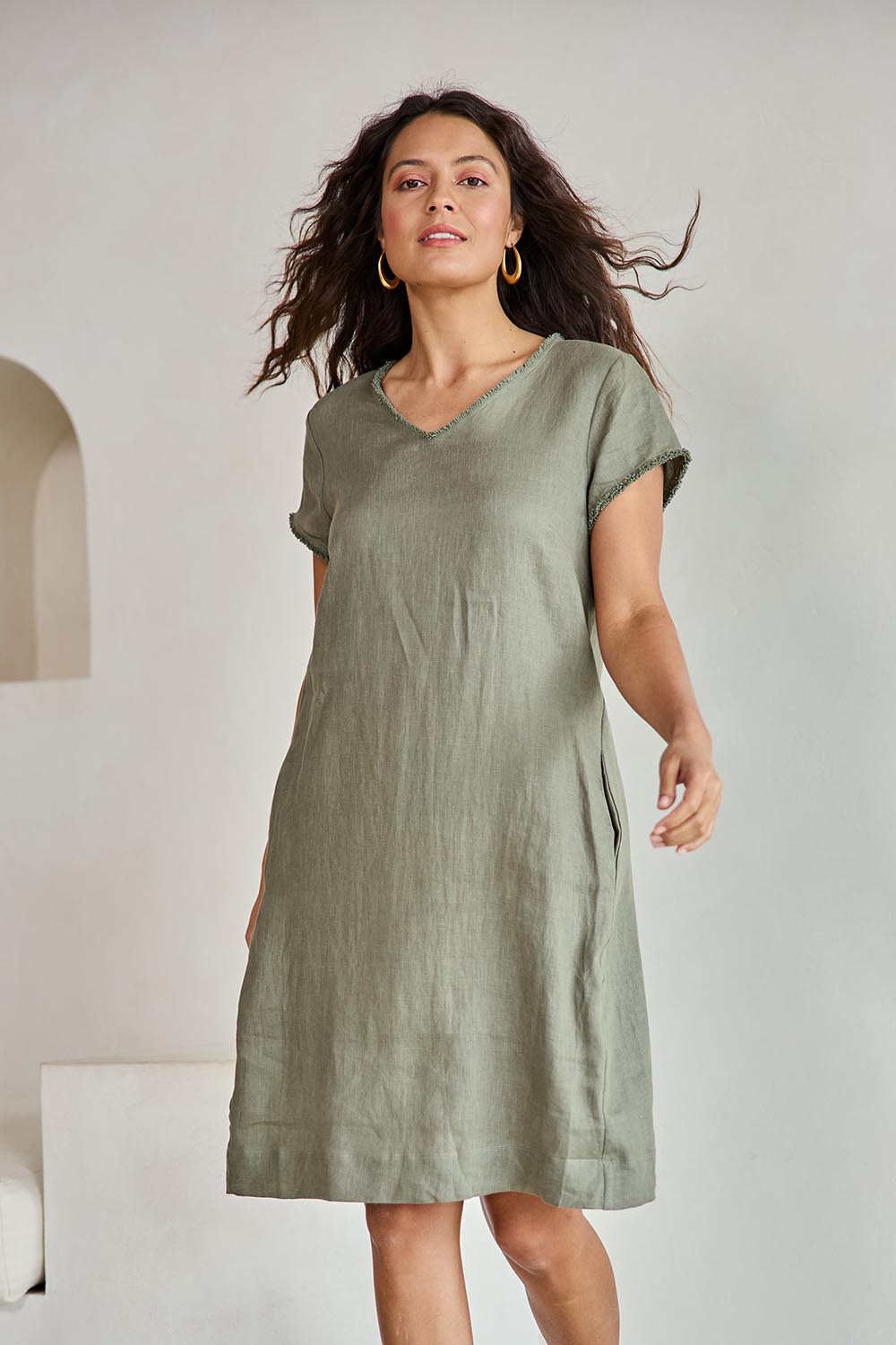 Model Tahneei wearing size 10 of the Linen V Neck Shift Dress – Olive in colour Olive, in a cropped view