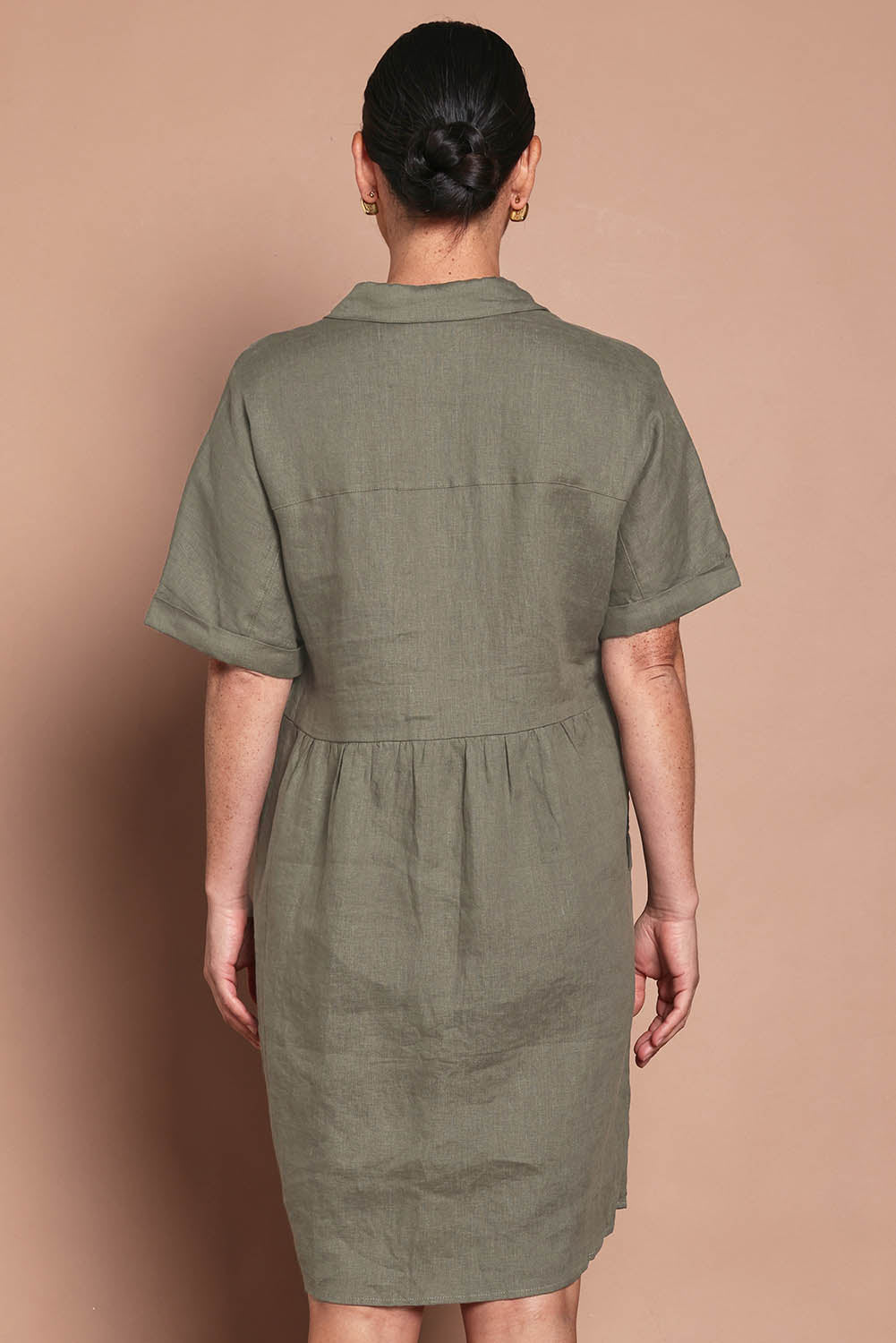 Model Katie wearing size 10 of the Linen Throw On Dress in colour Olive (Green), from the back