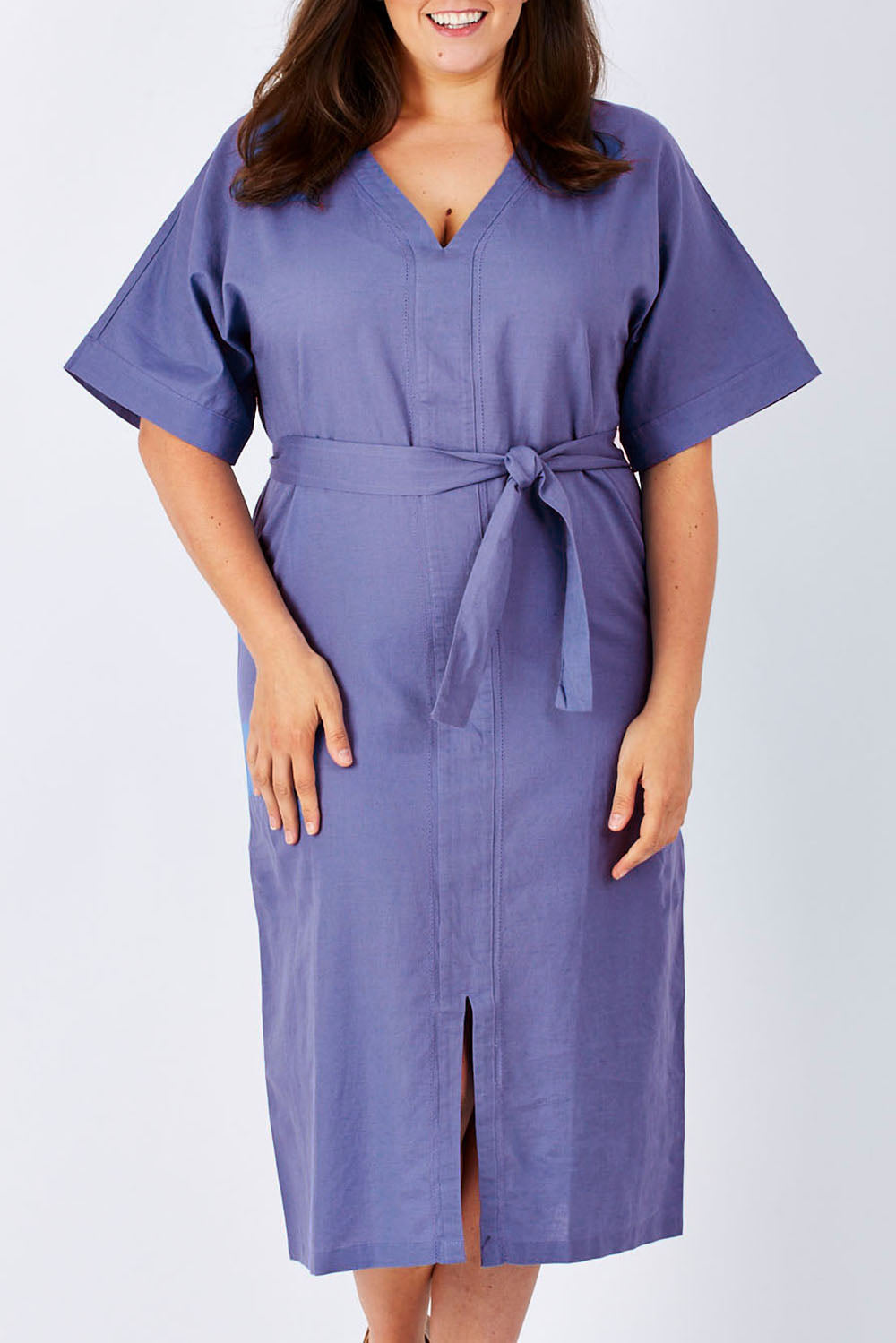 Model Mae wearing size 18 of the Natural Throw Dress in colour Fleet (Blue), from the front, cropped image