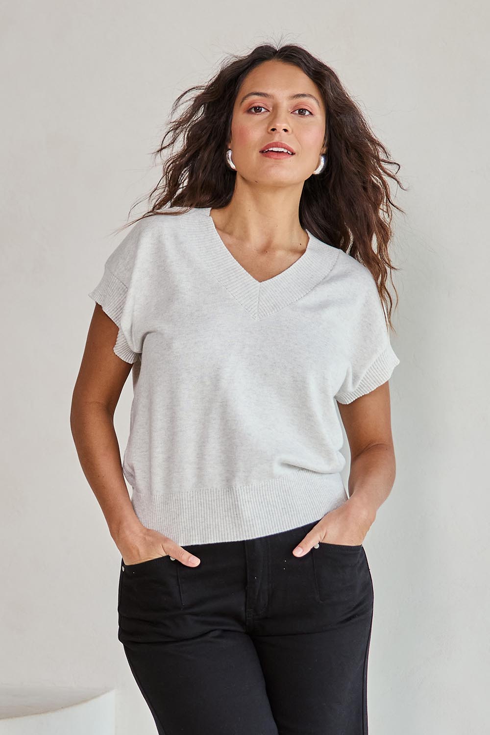 Model Tahneei wearing size 10 of the Cotton Cashmere Relaxed Knit – Dove in colour Dove, in a cropped view
