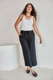 Model Tahneei wearing size 10 of the Linen Cropped Drawstring Pant – Black in colour Black, from the front