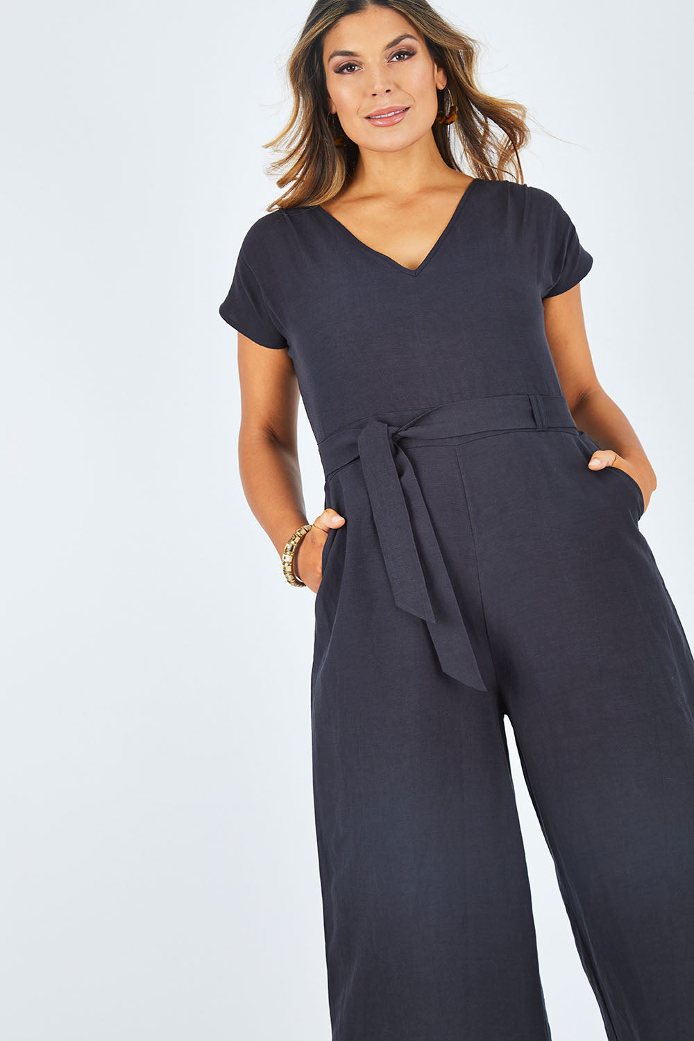 Model Palatina wearing size 14 of the Linen Blend Jumpsuit in colour Raven (Blue), from the front, cropped image