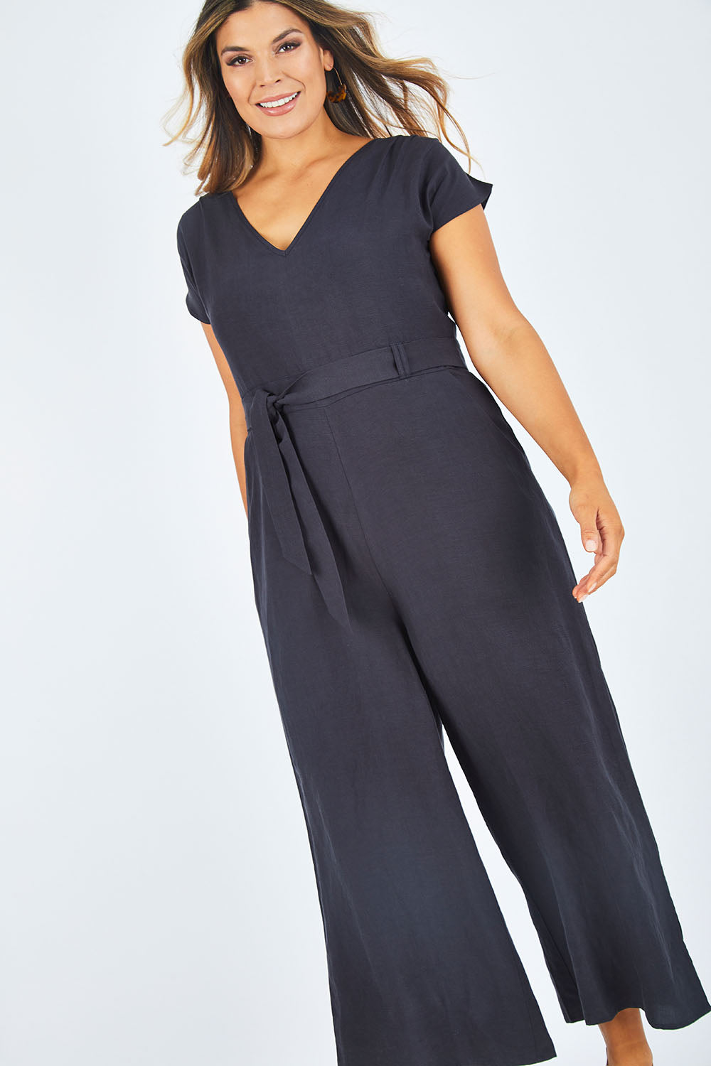 Model Palatina wearing size 14 of the Linen Blend Jumpsuit in colour Raven (Blue), from the front, showing the whole outfit