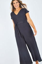 Model Palatina wearing size 14 of the Linen Blend Jumpsuit in colour Raven (Blue), from the front, showing the whole outfit