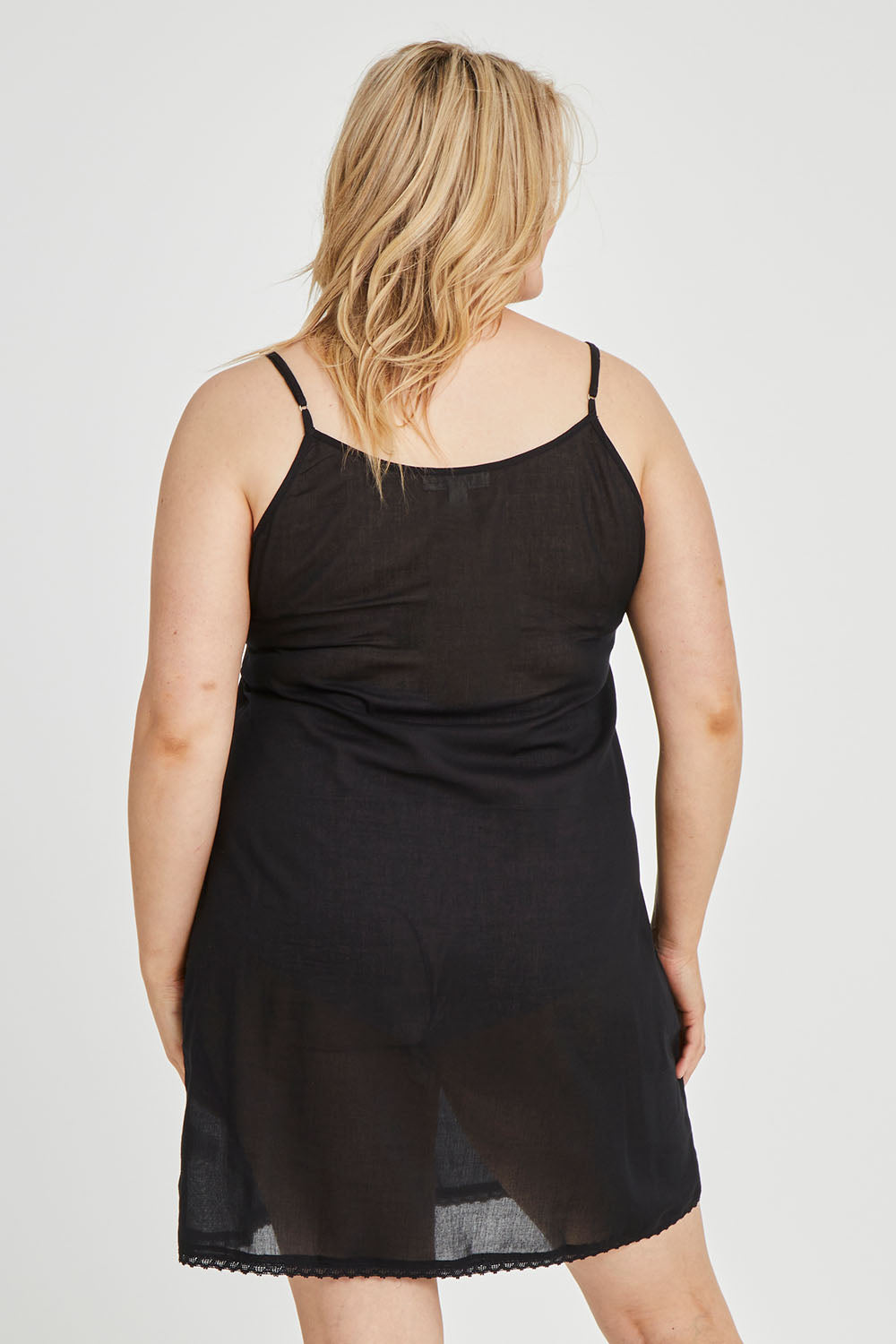 Model Keeara wearing size 16 of the Cotton Slip in colour Black (Black), from the back