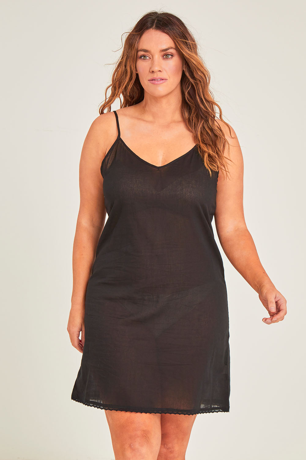 Model Laura wearing size 14 of the Cotton Slip in colour Black (Black), from the front, cropped image