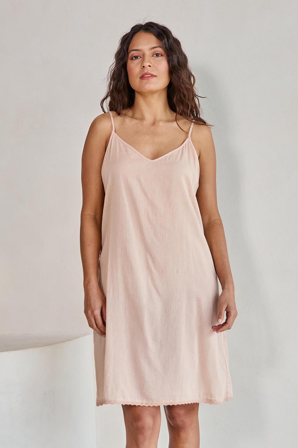 Model Tahneei wearing size 10 of the Cotton Slip - Sand in colour Sand, in a cropped view