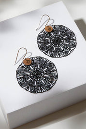 A model wearing size OneSize of the Coco Cut Out Earring in colour Coco (Black), from the front, showing the whole outfit
