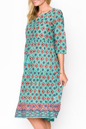 A model wearing the Rebecca Cotton Tie Neck Dress in colour Diamond1 (Blue), from the front, cropped image