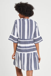 Model Aiyana wearing size 10 of the Maya Button V Neck Layer Dress in colour Navy (Blue), from the back