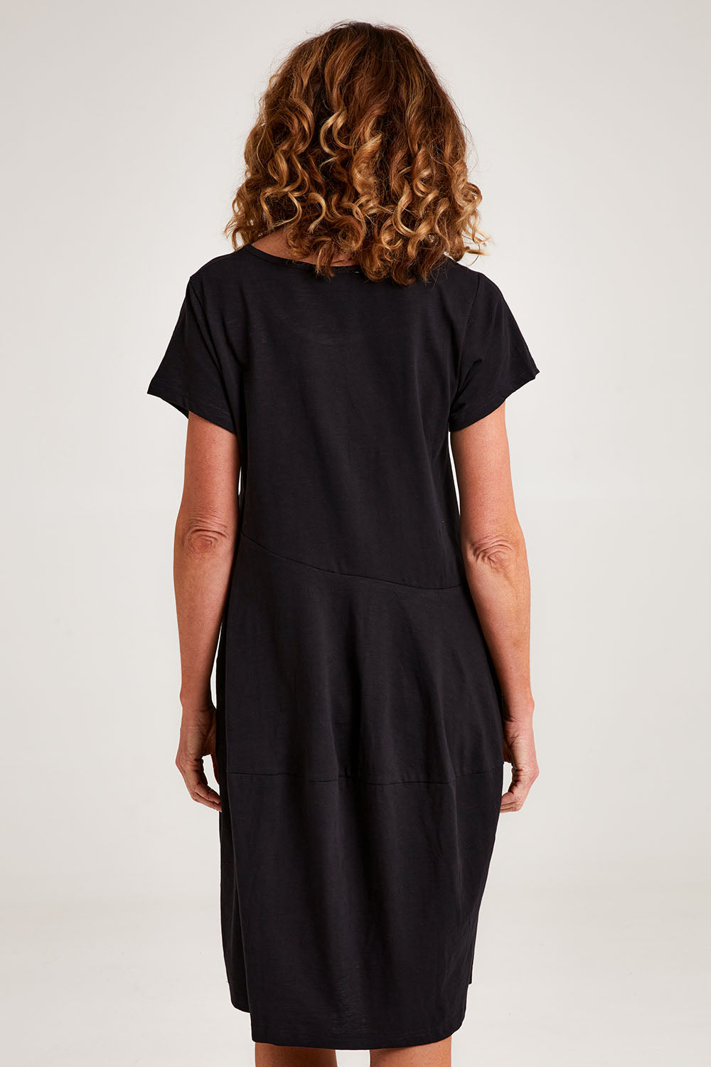 Model Emma wearing size 10 of the Essentials Organic Cotton Bubble Dress in colour Black (Black), from the back