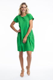 A model wearing the Essentials Knit Bubble Dress in colour Parakeet (Green), from the front, showing the whole outfit