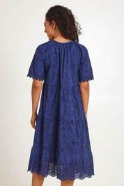 Model Pamelar wearing size 10 of the Essentials Broderie Layers Dress - Navy in colour Navy, from the back