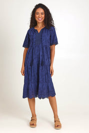 Model Pamelar wearing size 10 of the Essentials Broderie Layers Dress - Navy in colour Navy, from the front